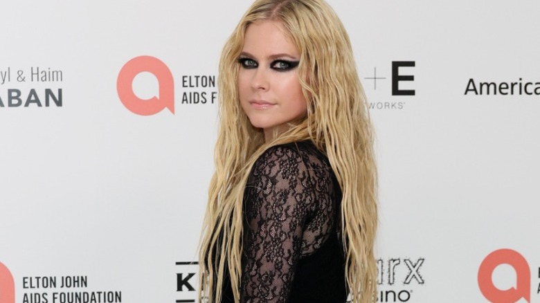 Avril Lavigne poses wearing a black lacy dress
