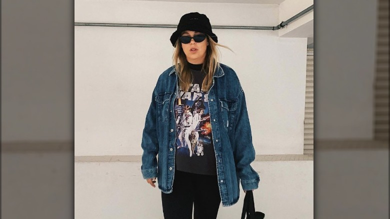 A woman wearing an oversized denim jacket