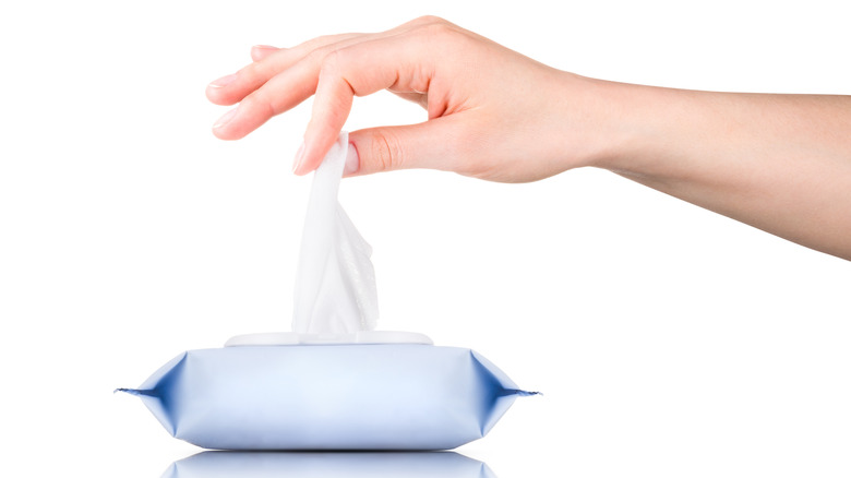 A hand taking a baby wipe