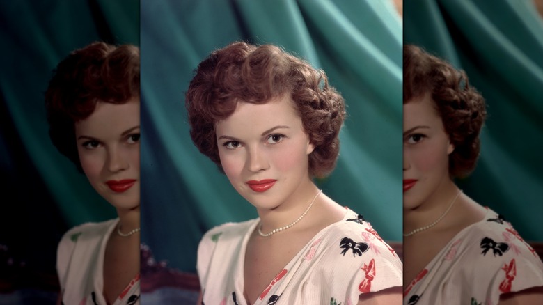 Shirley Temple posing with pin curls in 1955