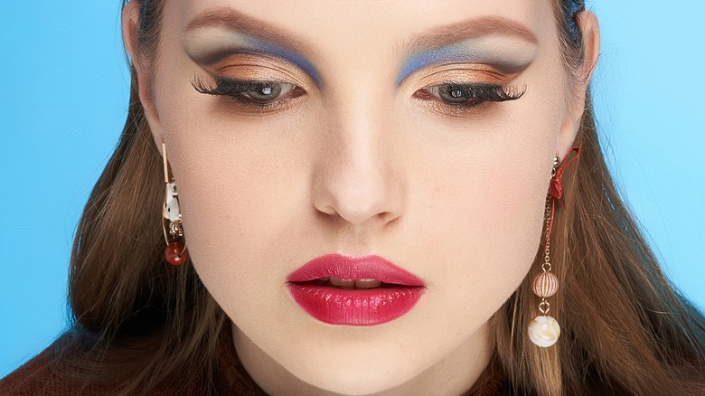 A woman wearing asymmetrical earrings