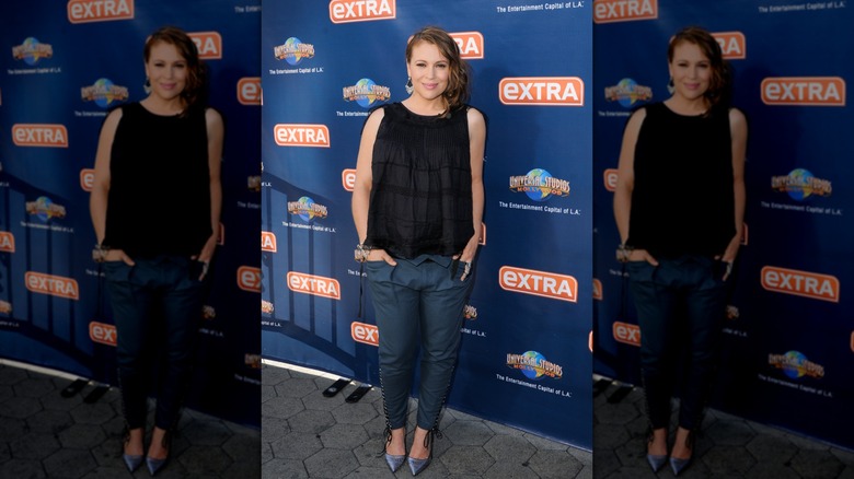 Alyssa Milano wearing a flowy top and slim-fitting pants while pregnant