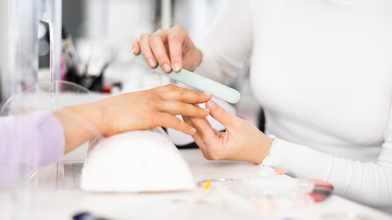 woman getting nails done in salon