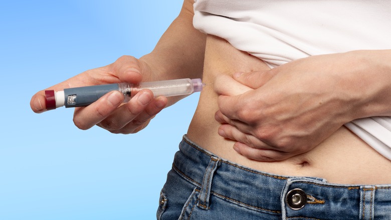 Woman injecting herself with insulin