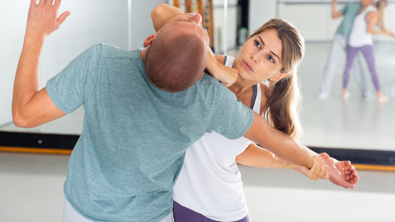 Woman hitting man with elbow