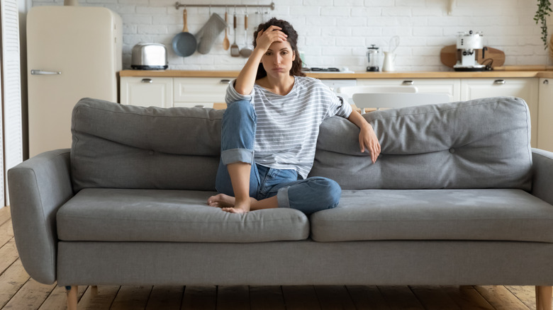 Woman sitting on the couch looking defeated
