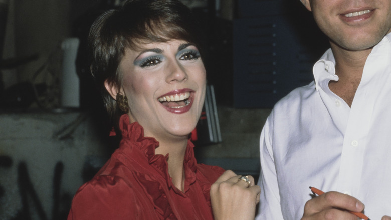 woman with blue eyeshadow laughing