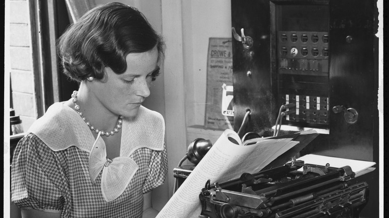  A woman reading at her desk in an office in the 1930's. 