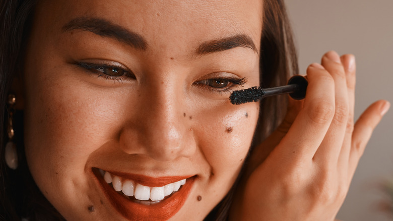 Woman applying mascara