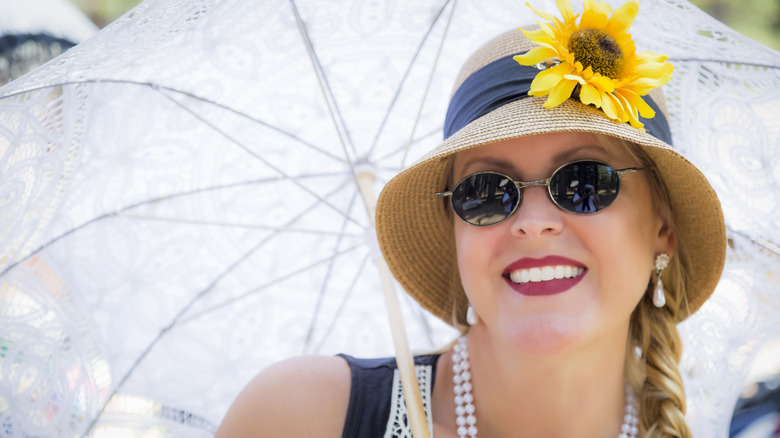 A woman in 1930s dress wearing sunglasses