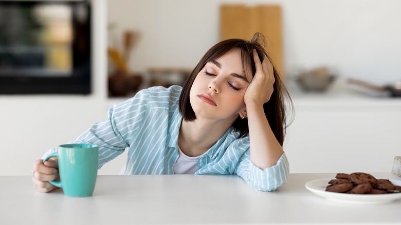 Woman sleeping holding coffee cup