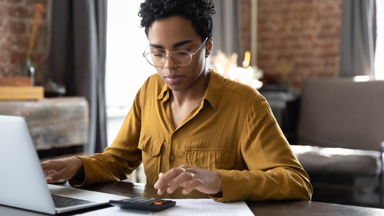 Busy woman working on calculator