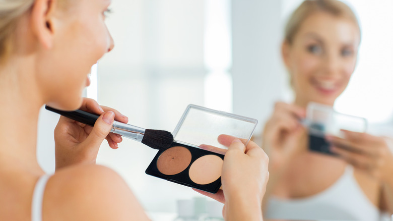Woman holding makeup, brush