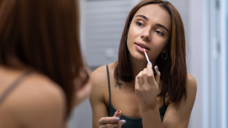 Woman applying lipgloss