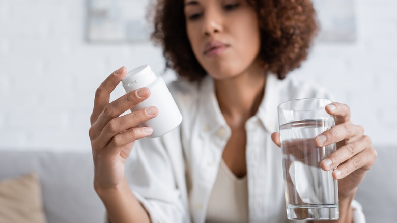 Woman inspecting the label of her pills