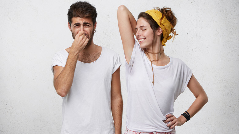 man plugging nose to smelly woman