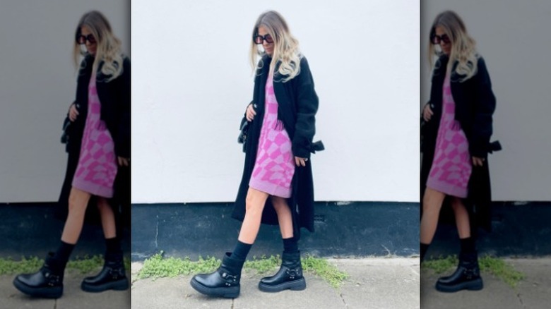 woman wearing navy duster over pink checkered mini dress