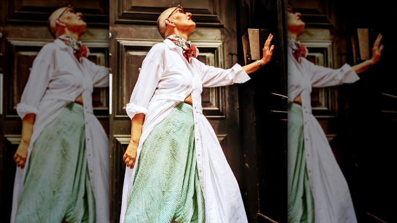 person wearing white duster coat over green skirt