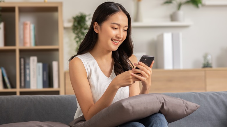 Woman happily using her phone