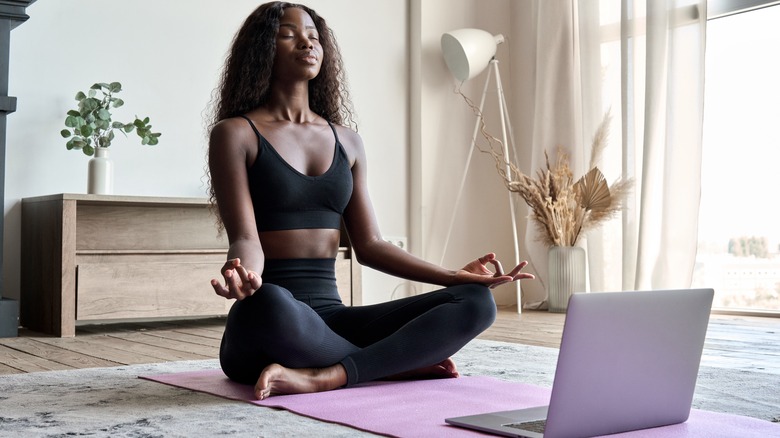 woman meditating on yoga mat