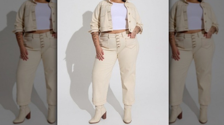 Person in cream denim jacket and jeans