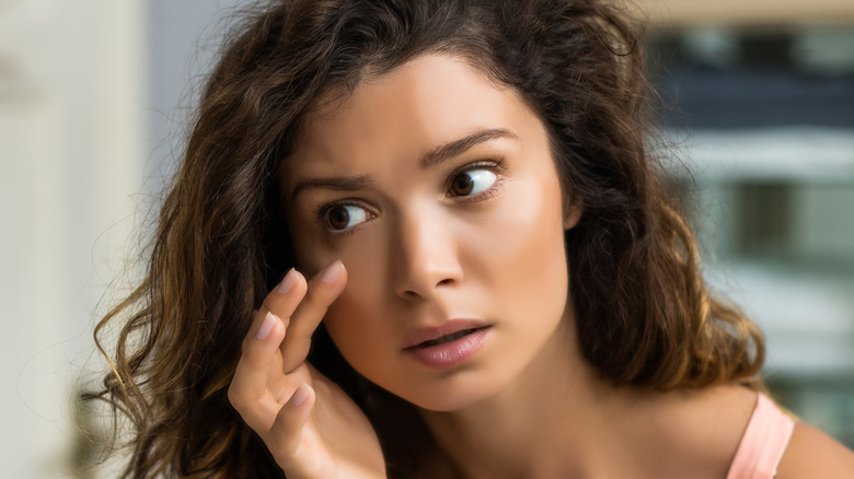 Woman examining her eye