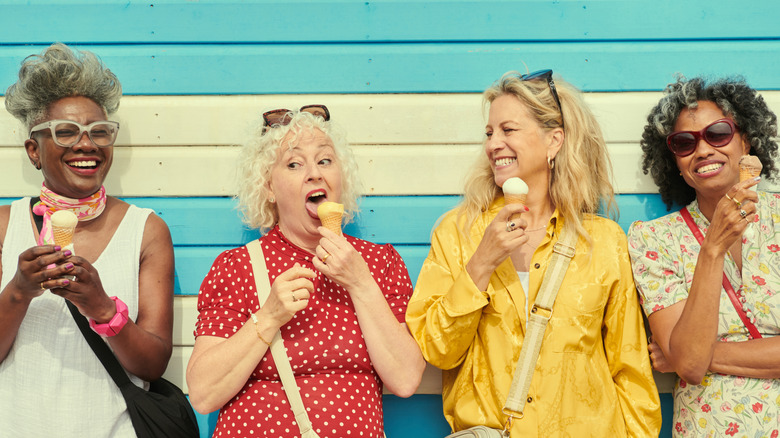 Four older women with various hairstyles eating ice cream cones