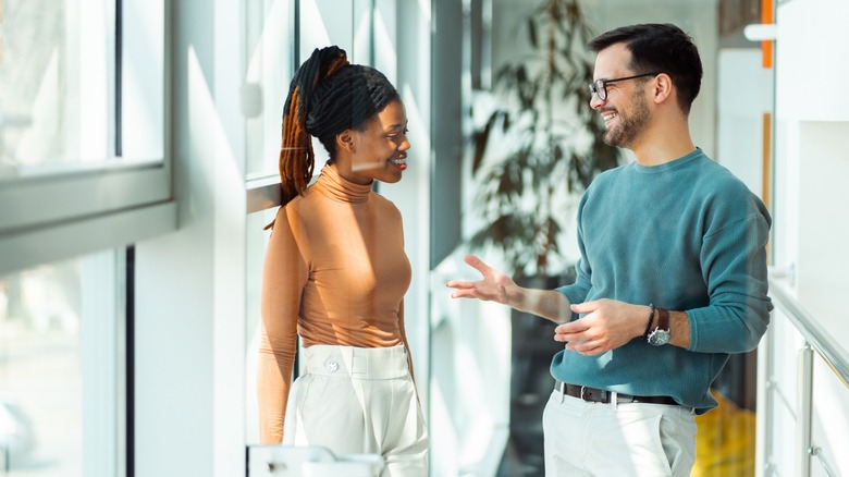 Two people laughing while talking to each other.