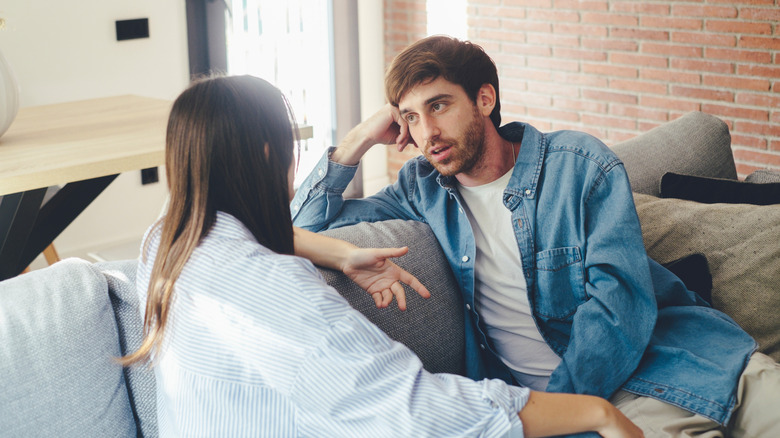 A couple talking on a couch.