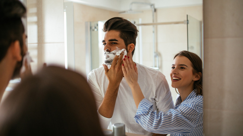 A woman and a man sharing a bathroom.