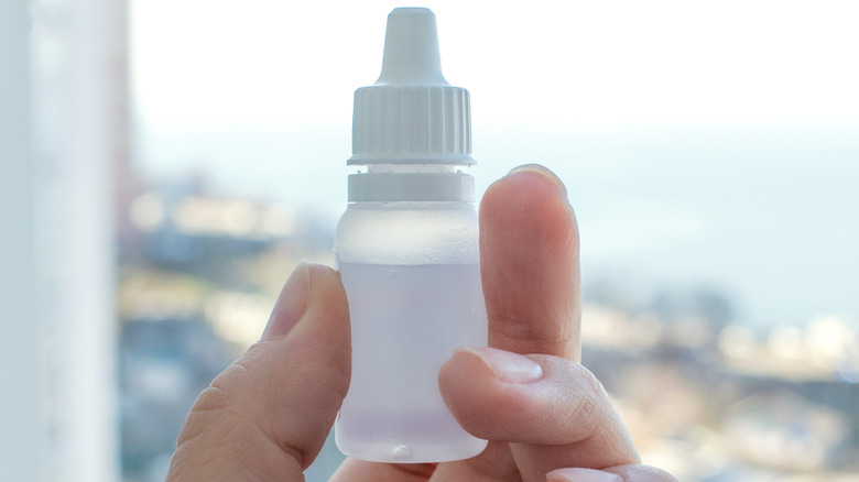woman holding eye drops