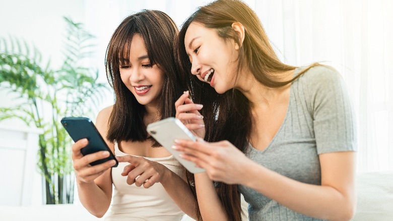 Woman laughing and looking at phones