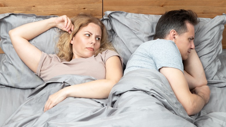 unhappy couple in bed