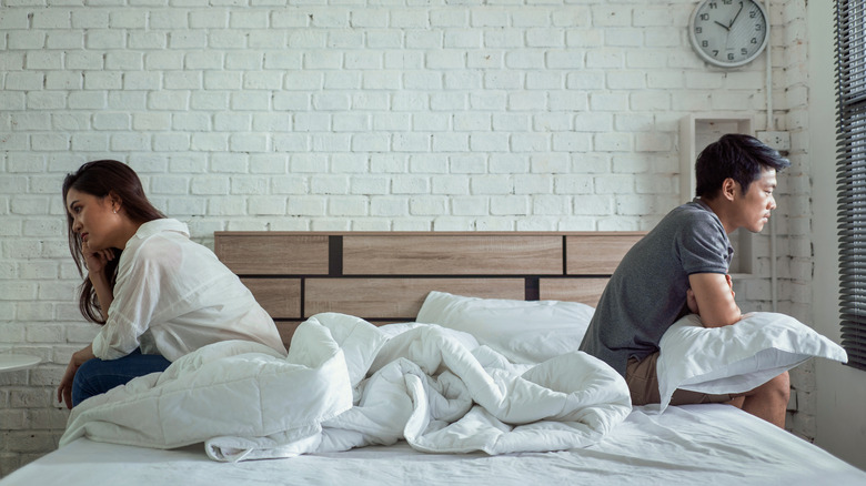 couple on opposite sides of bed