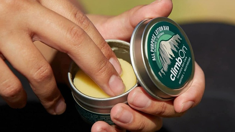 hands dipping in solid lotion