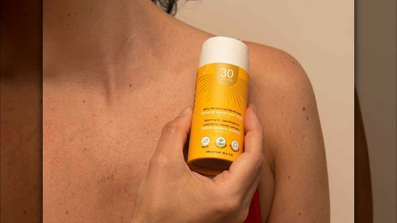 person applying SPF solid lotion