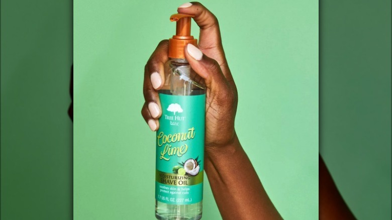 Hand holding shave oil bottle