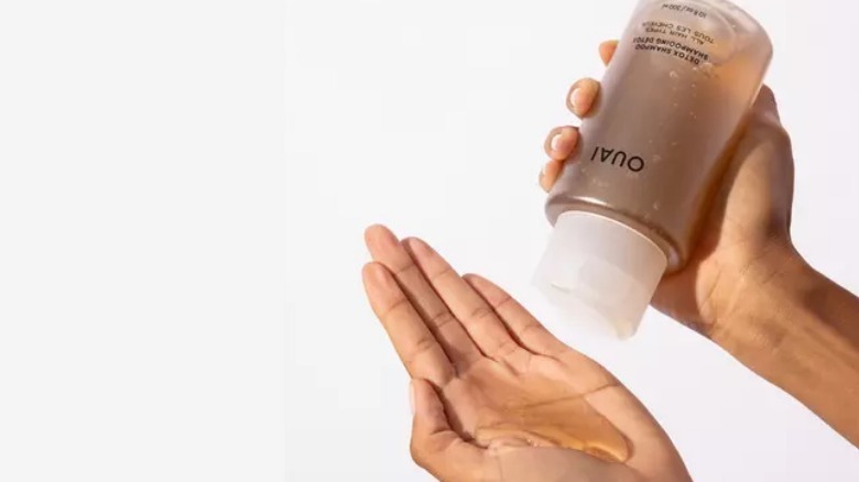 Holding yellow bottle of shampoo