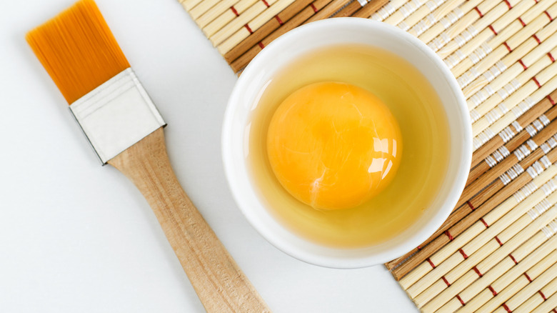 egg in a bowl next to a brush