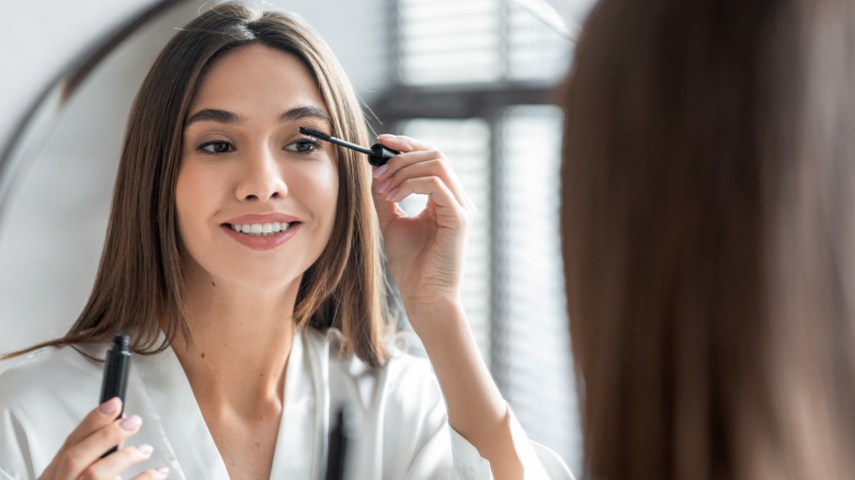 A woman applying mascara