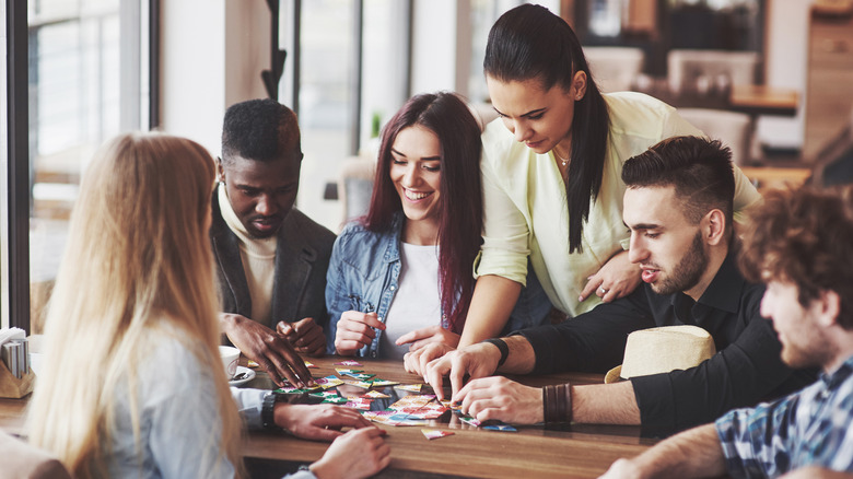 group of adults playing a board game