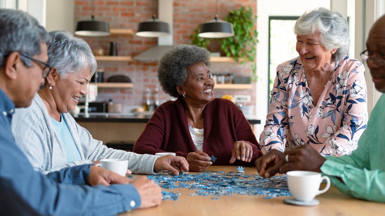 happy seniors putting a puzzle together