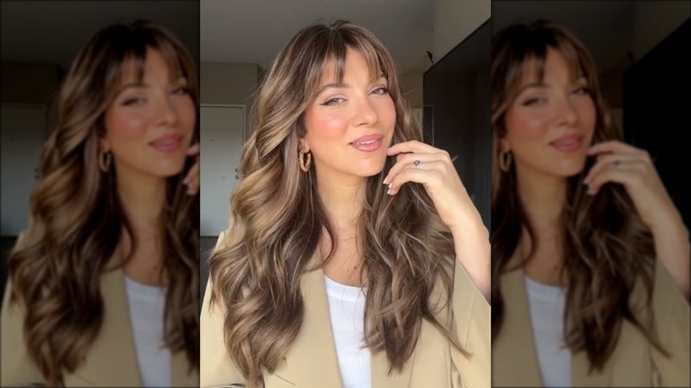 Woman with long wavy hair and fringe