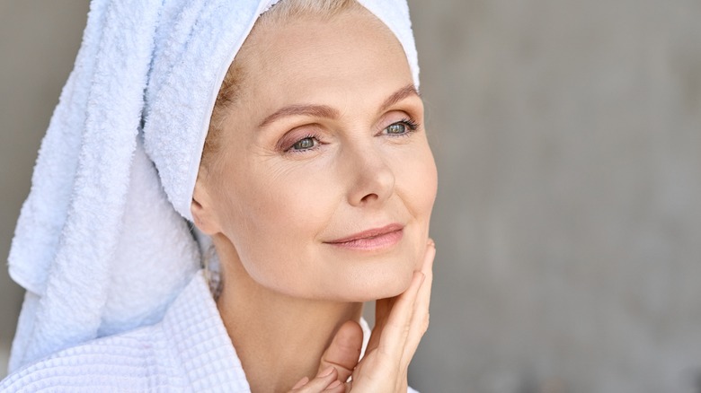 older woman touching face