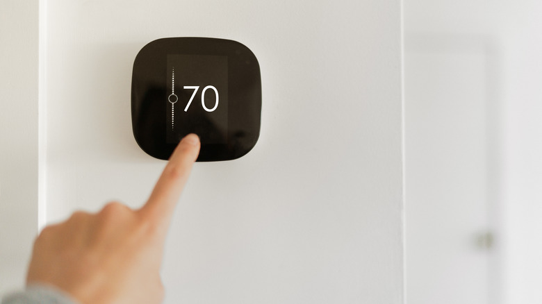 hand touching heater button