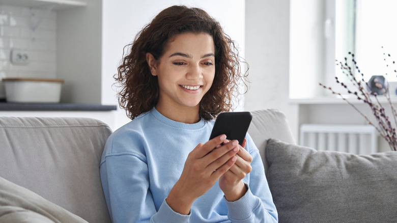 smiling woman looking at phone