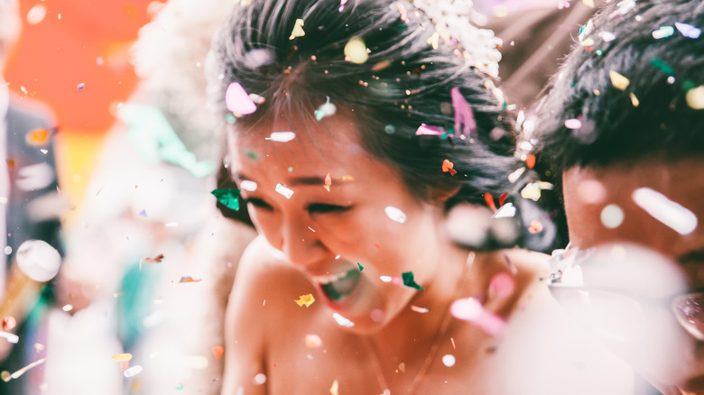Guests throwing petals around the bride 