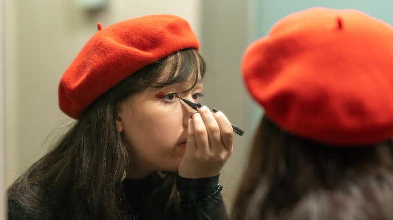 young woman applying eyeliner