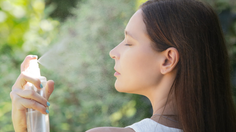 woman spraying her face