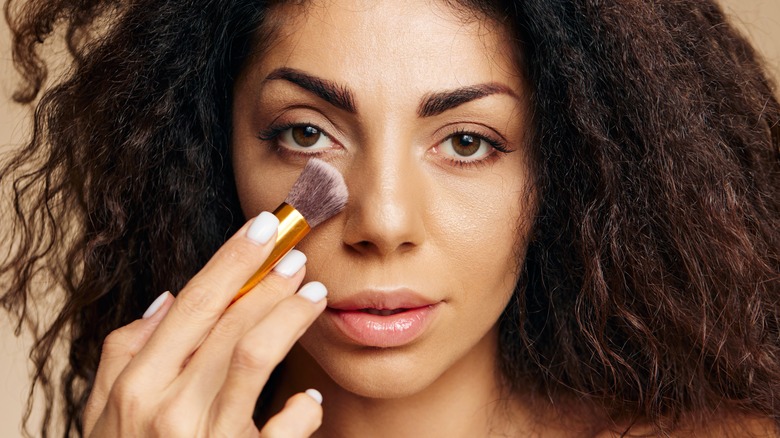 Woman applying undereye powder